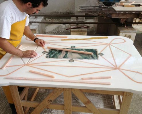 Custom waterjet cut table with various kinds of marble during the production procedure